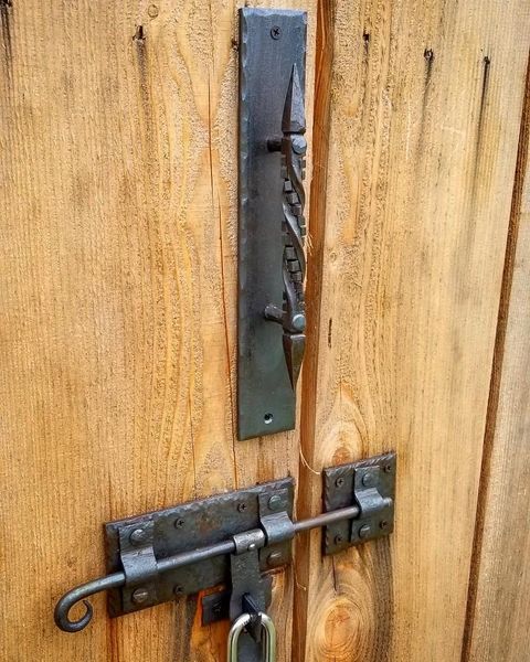 Forged door pull and gate latch installed on a wooden gate